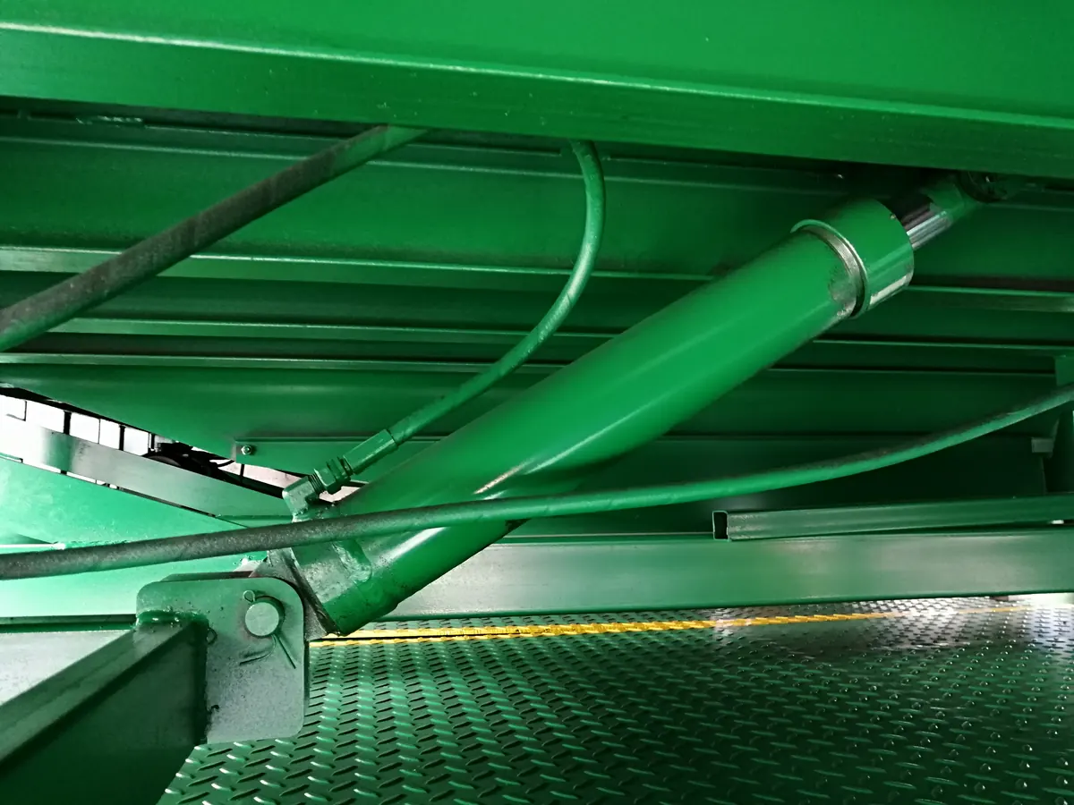 Close-up of a hydraulic cylinder and support members beneath a dock leveler platform