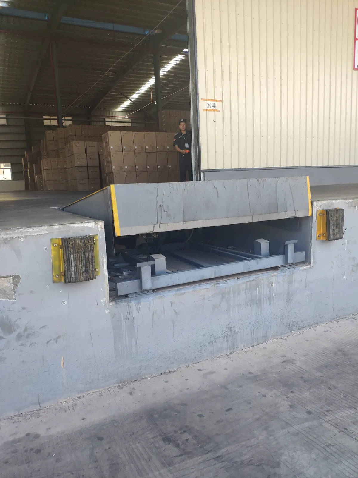 Dock leveler installed in a loading dock pit with the deck raised